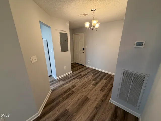 a view of a hallway with wooden floor and stairs