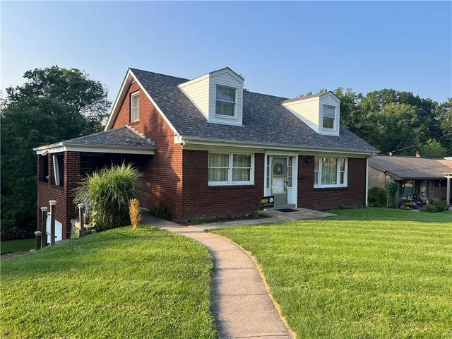 a front view of a house with a garden and yard