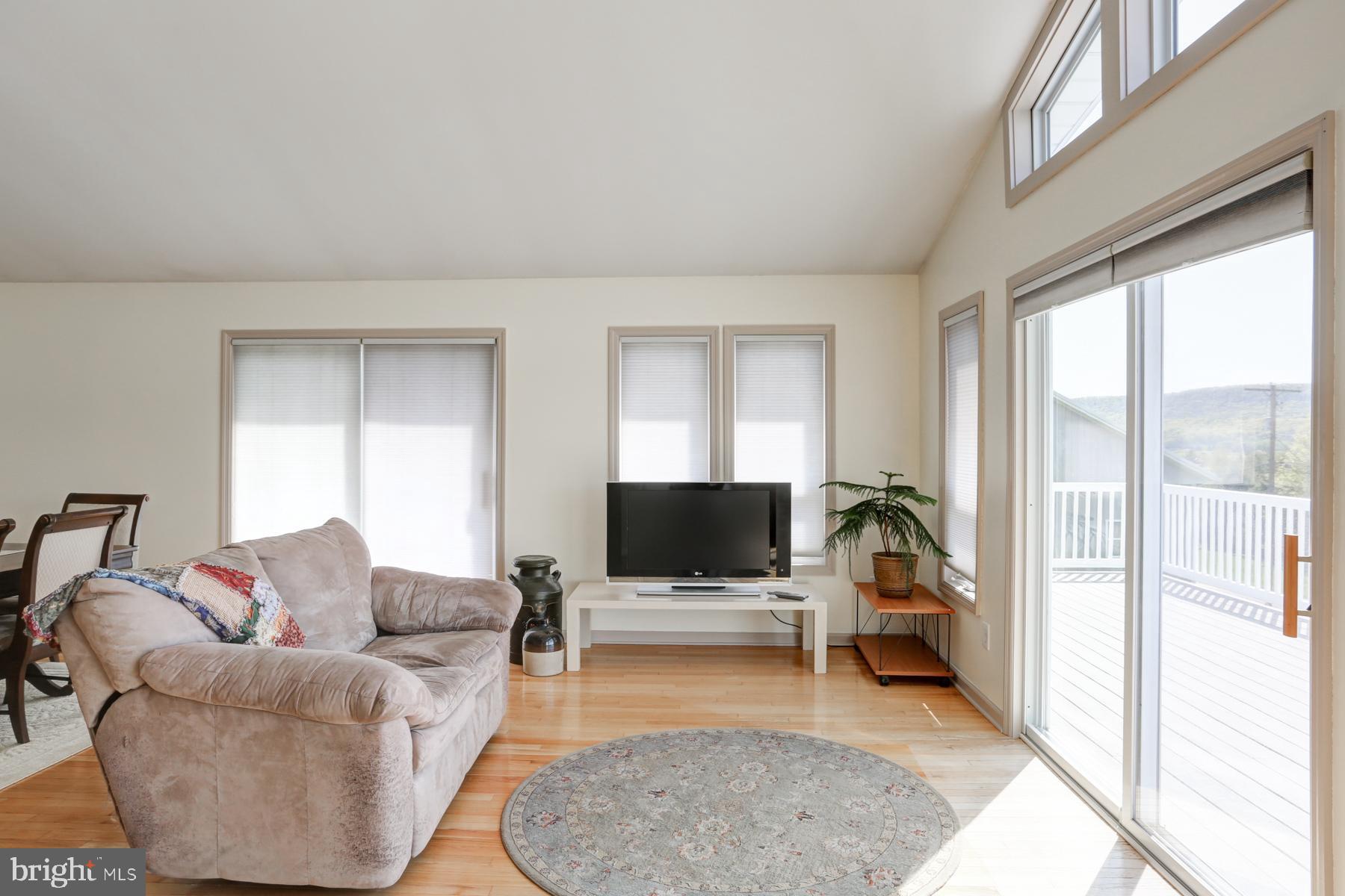 680 Powells Valley Road Halifax, PA 17032 - Photo 10 of 44 a living room with furniture a flat screen tv and a floor to ceiling window