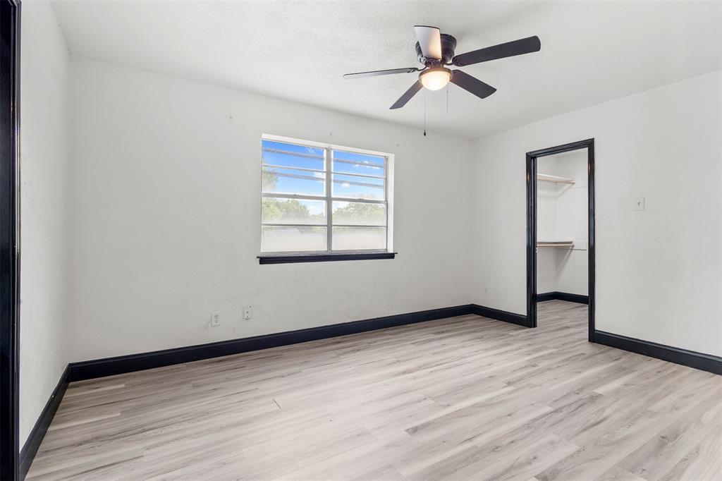 2802 Spring Valley Drive Bedford, TX 76021 - Photo 16 of 24 an empty room with wooden floor ceiling fan and windows