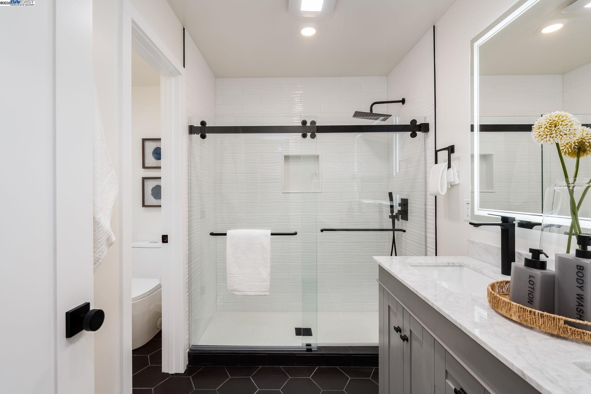1425 Camino Verde Walnut Creek, CA 94597 - Photo 12 of 28 a bathroom with a double vanity sink a mirror a shower and a bathtub