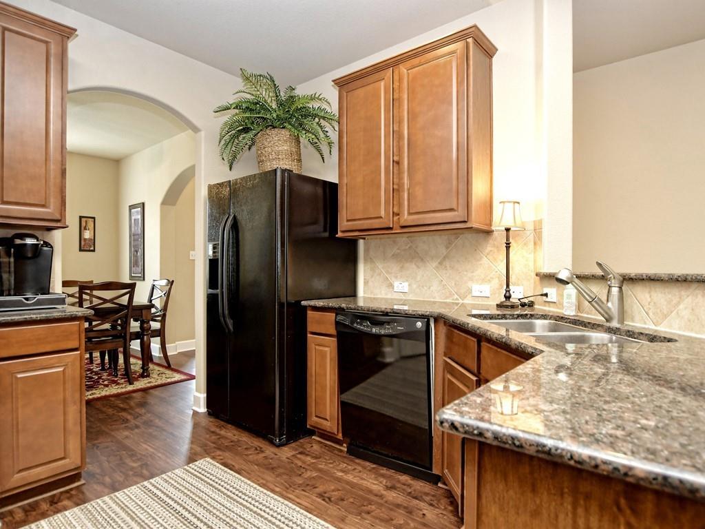 241 Caddo Lake Drive Georgetown, TX 78628 - Photo 11 of 25 a kitchen with stainless steel appliances granite countertop a refrigerator a stove and a wooden cabinets