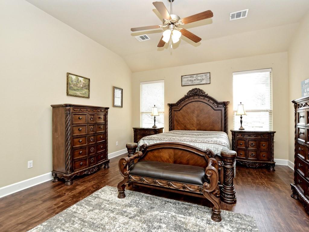 241 Caddo Lake Drive Georgetown, TX 78628 - Photo 13 of 25 a bedroom with a bed and a chandelier