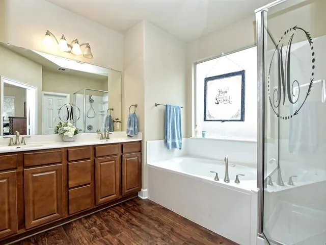 a spacious bathroom with a tub sink and mirror