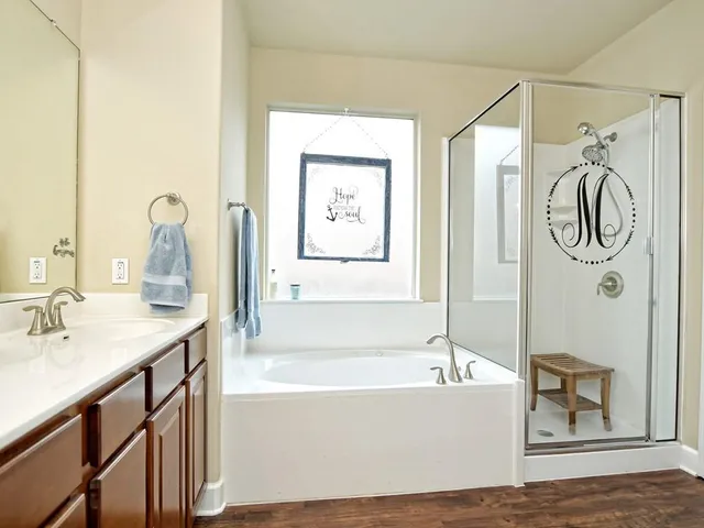 a bathroom with a tub sink and mirror