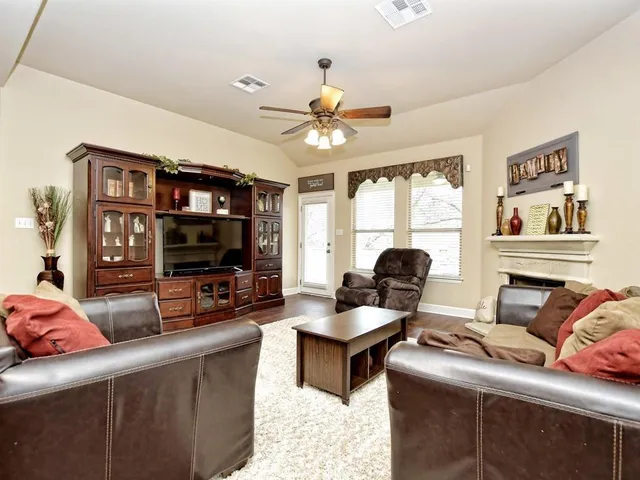 a living room with furniture a chandelier and a flat screen tv