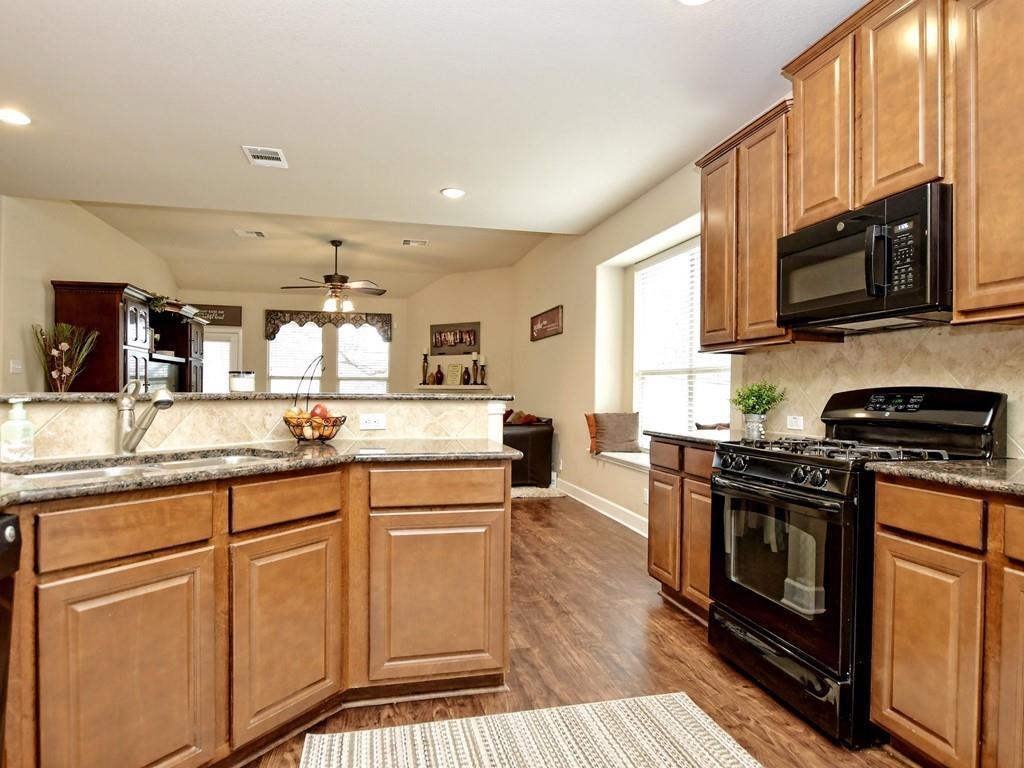 241 Caddo Lake Drive Georgetown, TX 78628 - Photo 10 of 25 a kitchen with stainless steel appliances granite countertop a stove a sink and a microwave
