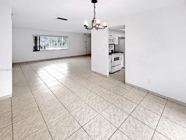 a view of a kitchen with an empty room and a window