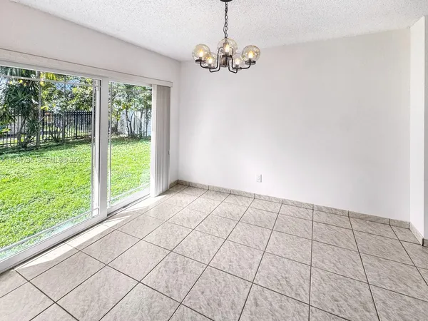 a large white kitchen with a stove a sink a microwave and cabinets