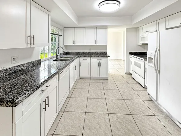 a kitchen with a sink a stove and cabinets