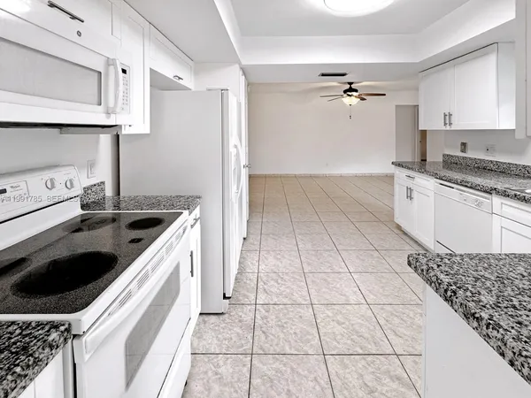 a kitchen with a refrigerator and a stove top oven