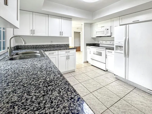 a kitchen with a sink a stove cabinets and window