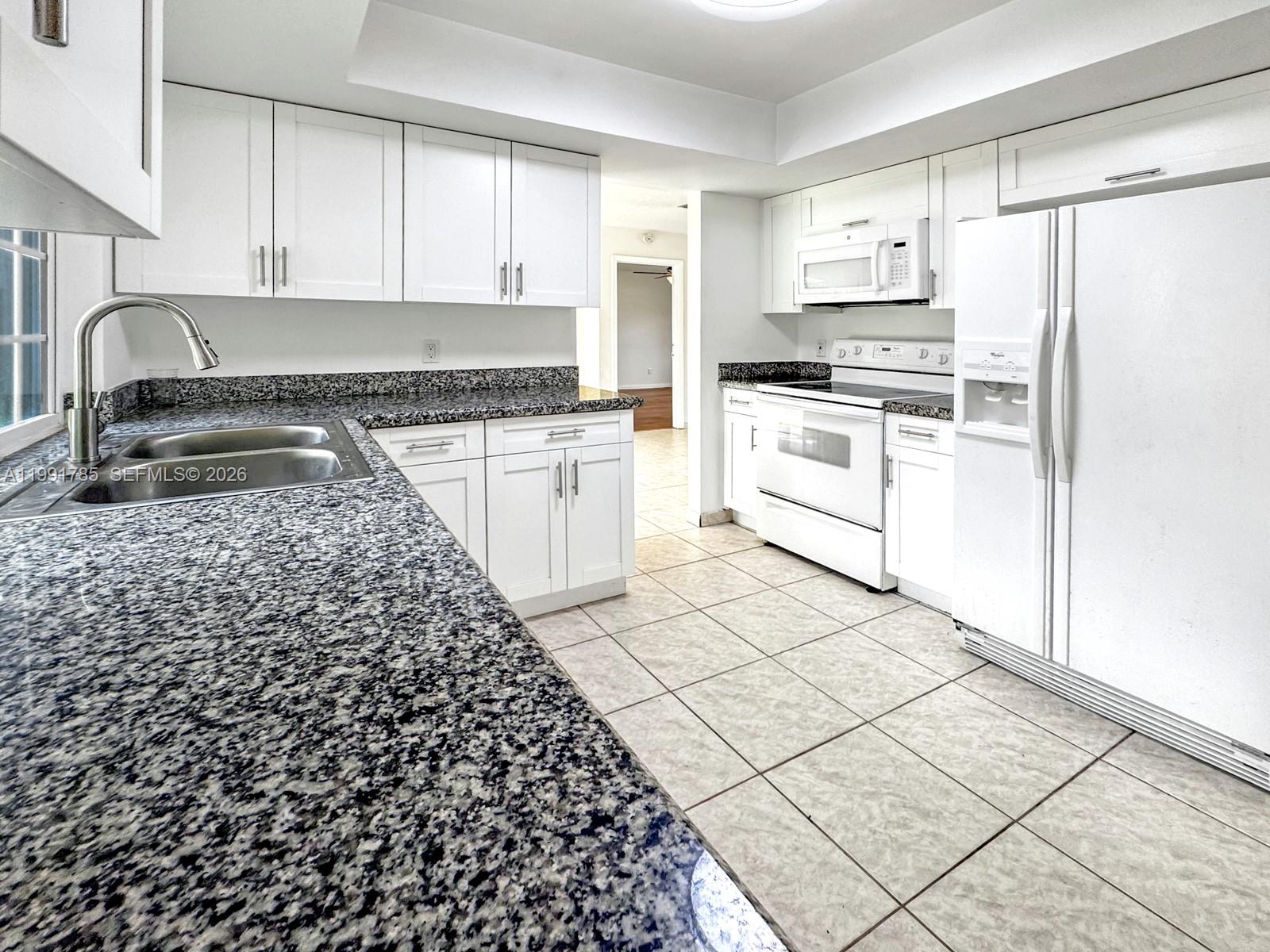 6802 Southwest 34th Court Miramar, FL 33023 - Photo 18 of 41 a kitchen with a refrigerator and a stove top oven