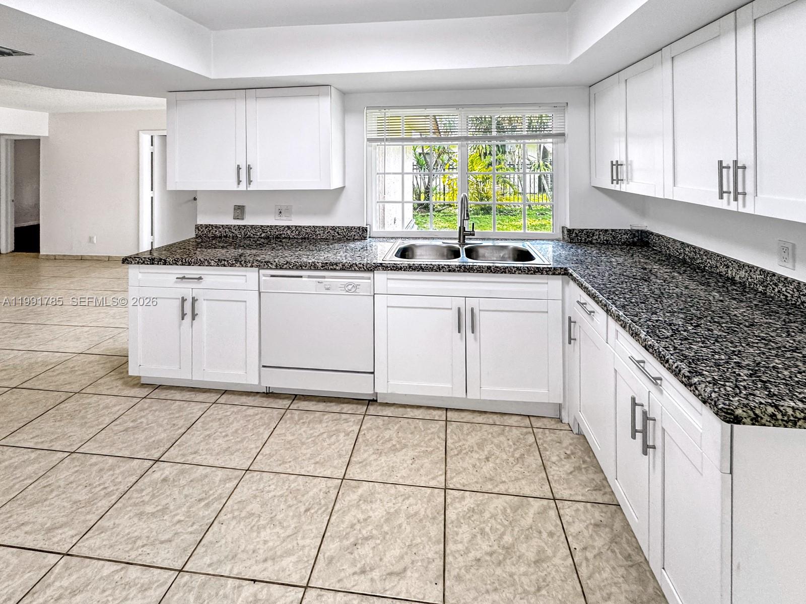6802 Southwest 34th Court Miramar, FL 33023 - Photo 19 of 41 a kitchen with a sink a stove cabinets and window