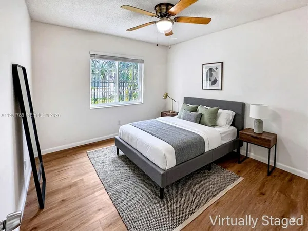 an empty room with a window and a ceiling fan