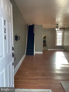 a view of a hallway with wooden floor and staircase