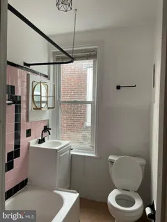 a bathroom with a sink a toilet and shower