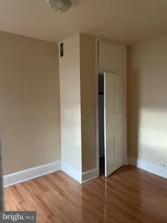 an empty room with wooden floor and closet
