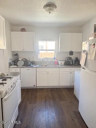a kitchen with a sink a stove and cabinets