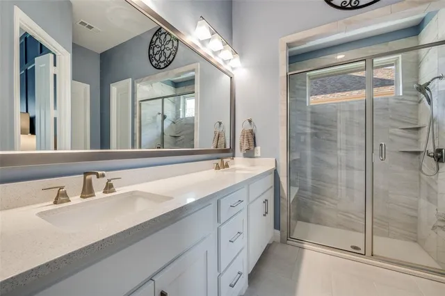 a bathroom with a granite countertop sink mirror and shower