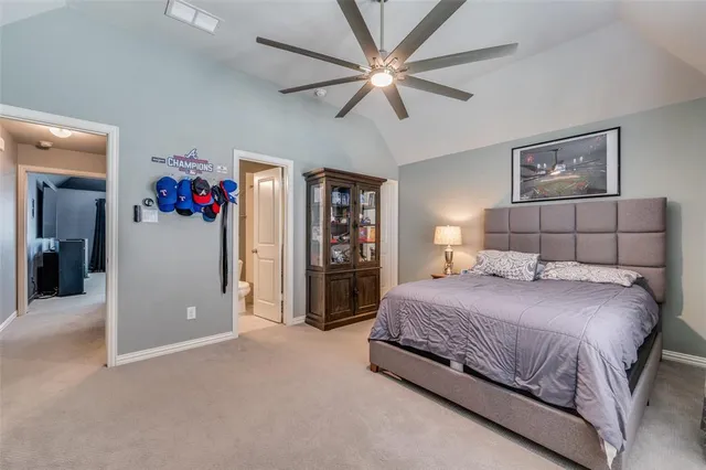 a bedroom with a large bed and a chandelier