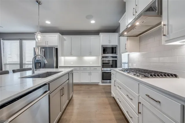 a kitchen with kitchen island white cabinets appliances and a counter top space