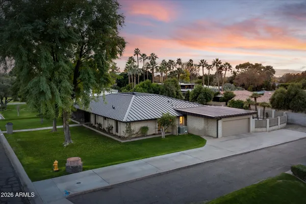 a view of a house with garden and a car park side of the road