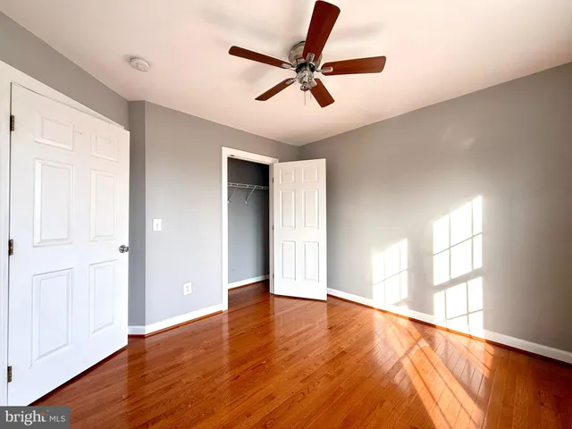 an empty room with window and a ceiling fan