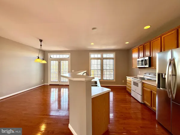 a kitchen with stainless steel appliances a stove a sink a microwave a refrigerator and cabinets