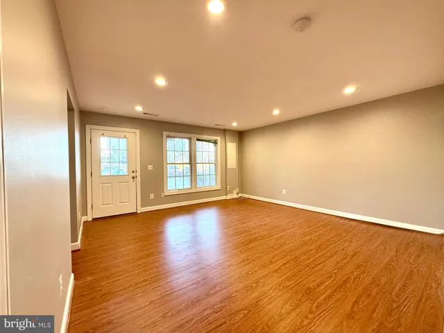 a view of an empty room with wooden floor