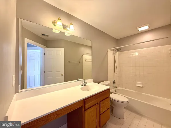 a view of an empty room and window with a ceiling fan