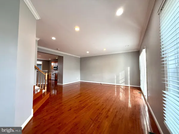 a view of empty room with wooden floor