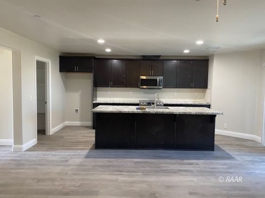 1124 South Yorktown Street Ridgecrest, CA 93555 - Photo 2 of 13 a kitchen with kitchen island stainless steel appliances a sink refrigerator stove and microwave