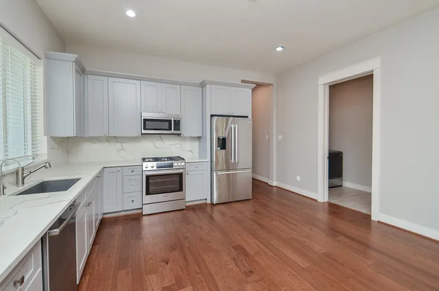 a kitchen with granite countertop a refrigerator stove and sink