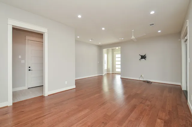 a view of empty room with wooden floor and windows