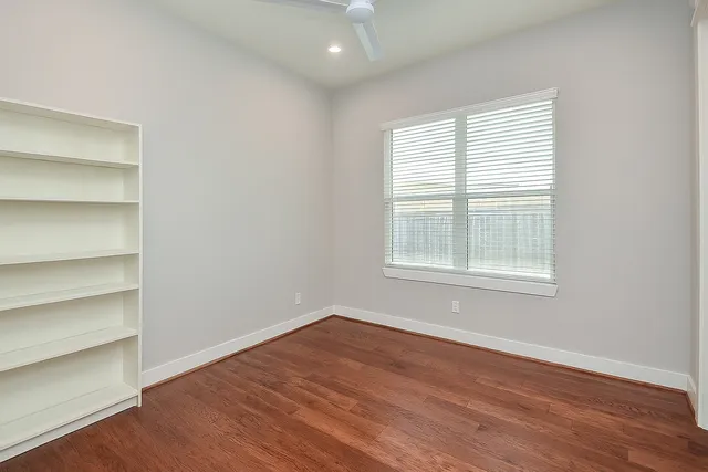 a view of a room with wooden floor and windows in it