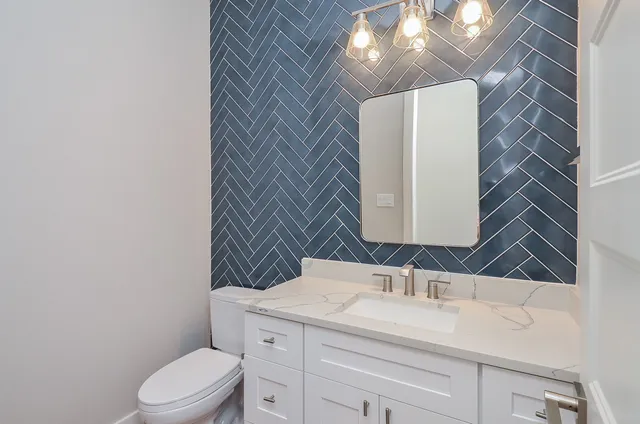 a bathroom with a sink vanity mirror and toilet