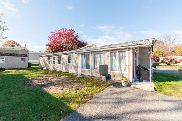 a view of a house with backyard and sitting area
