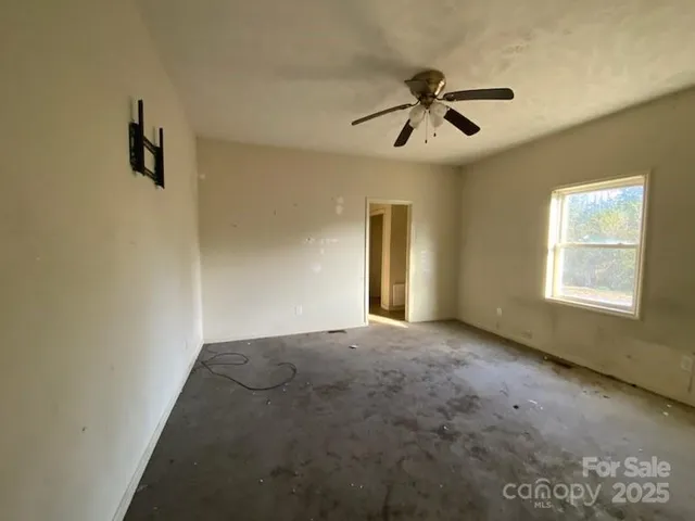 a view of a livingroom with a ceiling fan and window