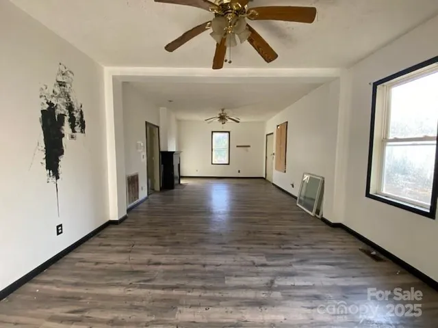 a view of a hallway view with wooden floor and chandelier