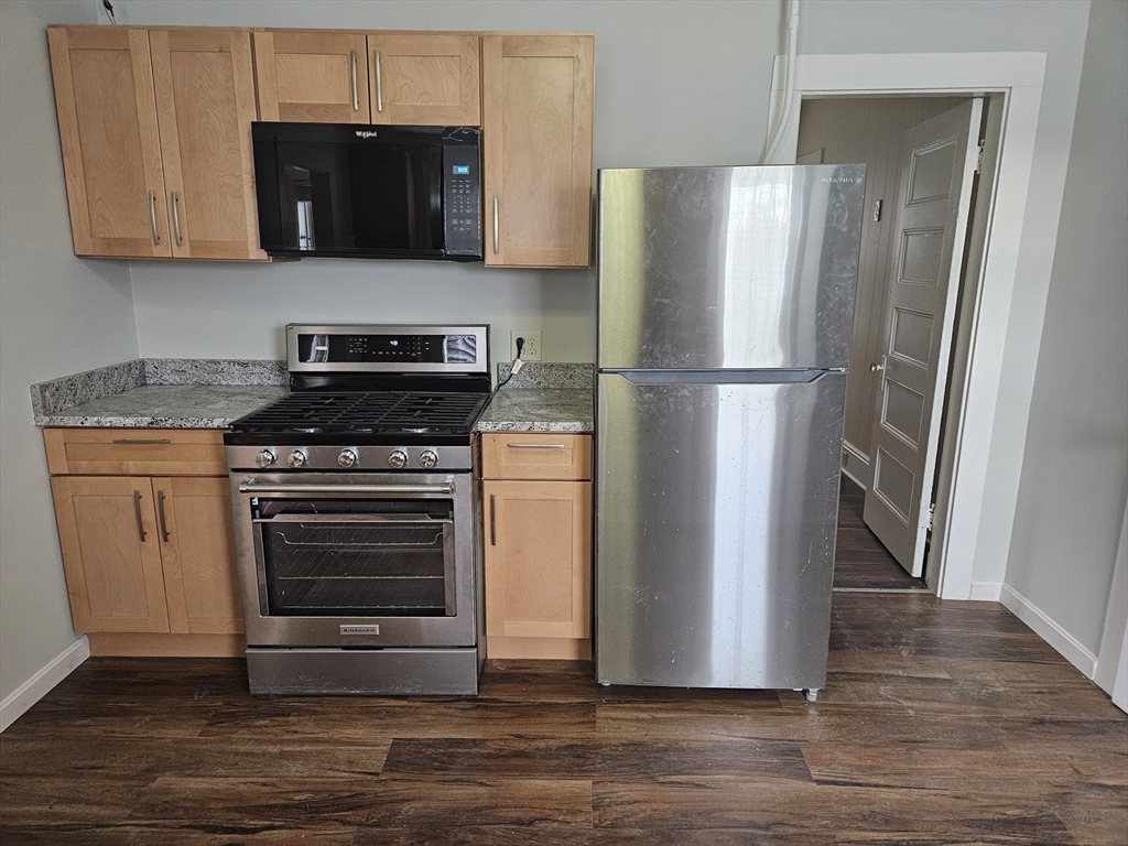 21 Baldwin Street, Unit 1 Malden, MA 02148 - Photo 1 of 19 a kitchen with a refrigerator stove and wooden cabinets