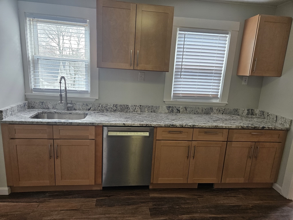 21 Baldwin Street, Unit 1 Malden, MA 02148 - Photo 2 of 19 a kitchen with granite countertop wooden cabinets a sink and a window