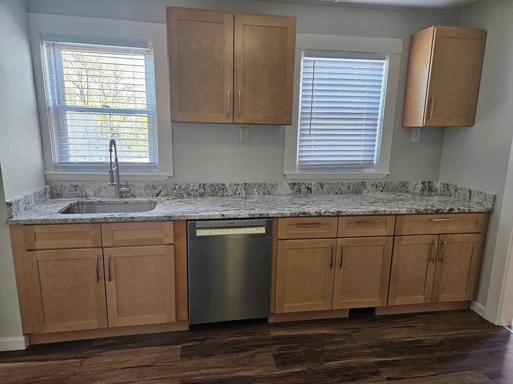 21 Baldwin Street, Unit 1 Malden, MA 02148 - Photo 3 of 19 a kitchen with granite countertop wooden cabinets a sink and a window