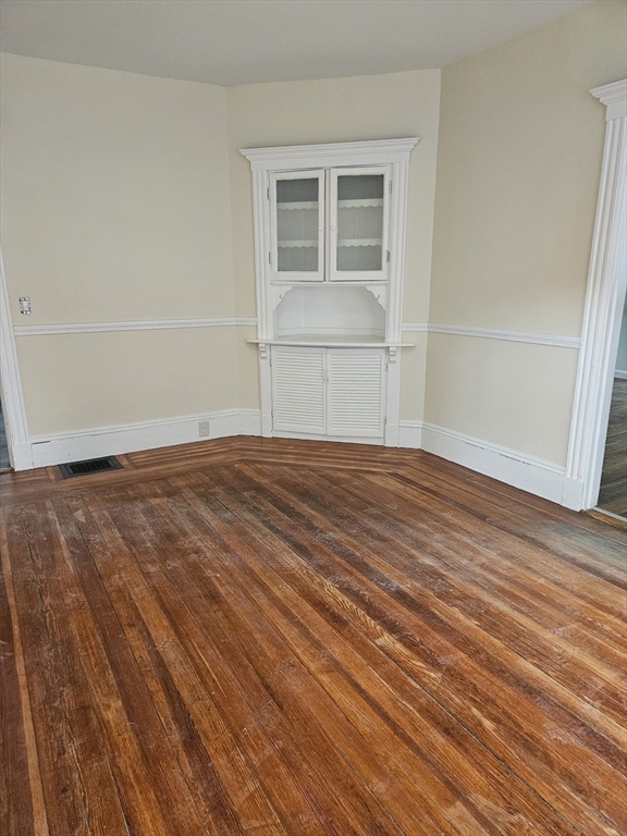 21 Baldwin Street, Unit 1 Malden, MA 02148 - Photo 6 of 19 a view of empty room with wooden floor and cabinet