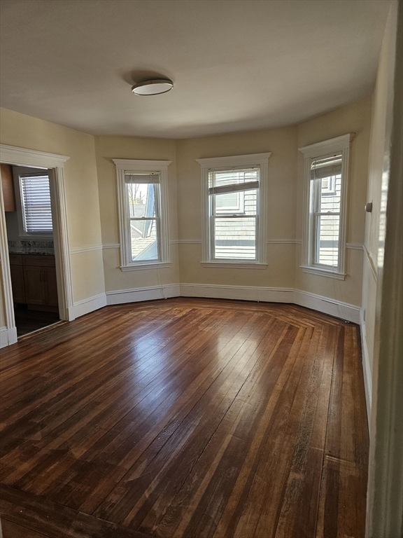 21 Baldwin Street, Unit 1 Malden, MA 02148 - Photo 9 of 19 a view of an empty room with wooden floor and a window