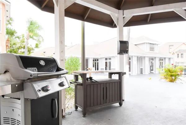 a living room with stainless steel appliances furniture a fireplace and a large window