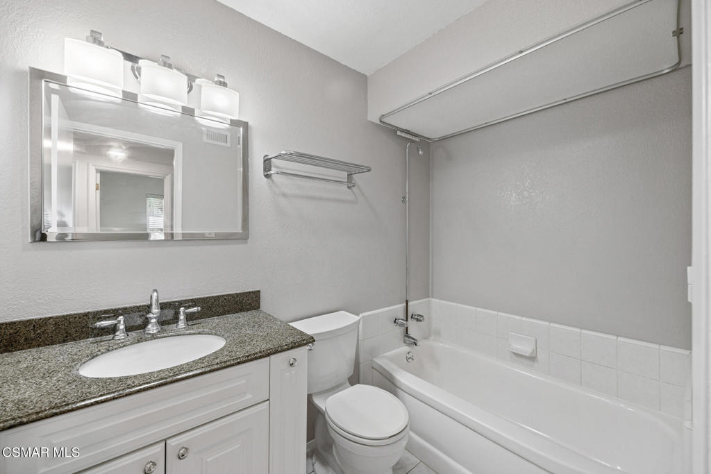 1521 Church Street Simi Valley, CA 93065 - Photo 13 of 16 a bathroom with a granite countertop sink a toilet a mirror and shower
