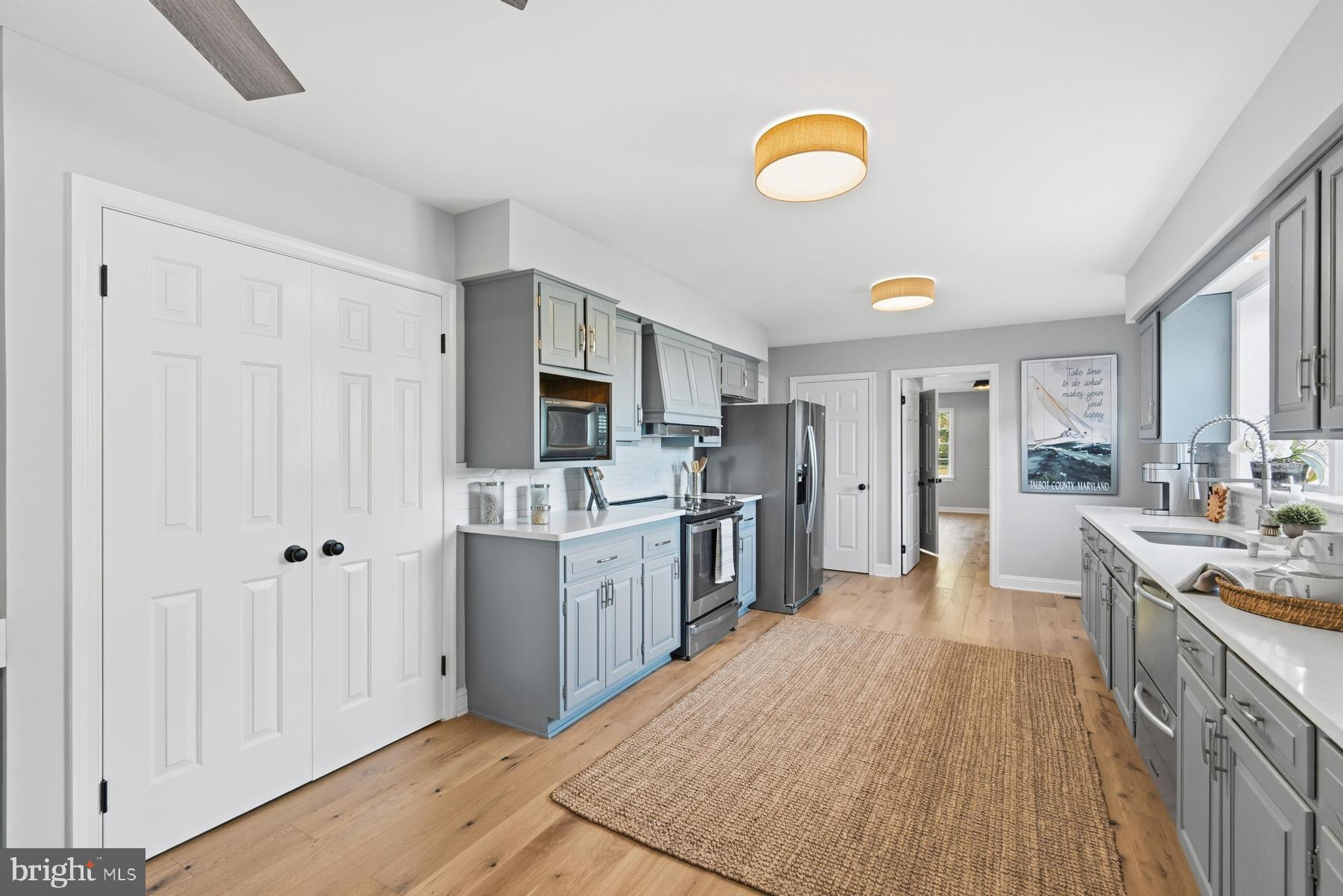 25500 Chance Farm Road St. Michaels, MD 21663 - Photo 13 of 43 a kitchen with stainless steel appliances granite countertop a stove top oven a sink dishwasher and a refrigerator with wooden floor
