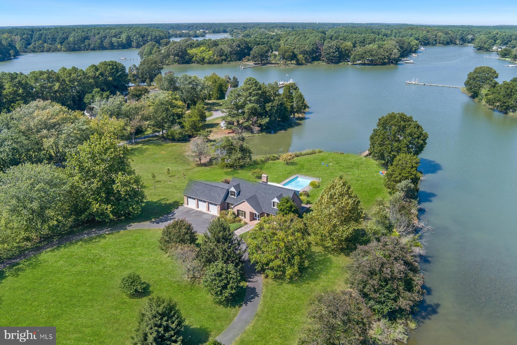 25500 Chance Farm Road St. Michaels, MD 21663 - Photo 2 of 43 an aerial view of green landscape with trees houses and lake view