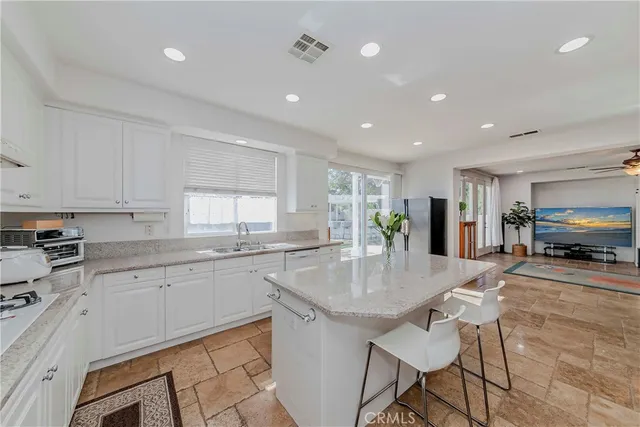 a kitchen with stainless steel appliances granite countertop a sink and a refrigerator